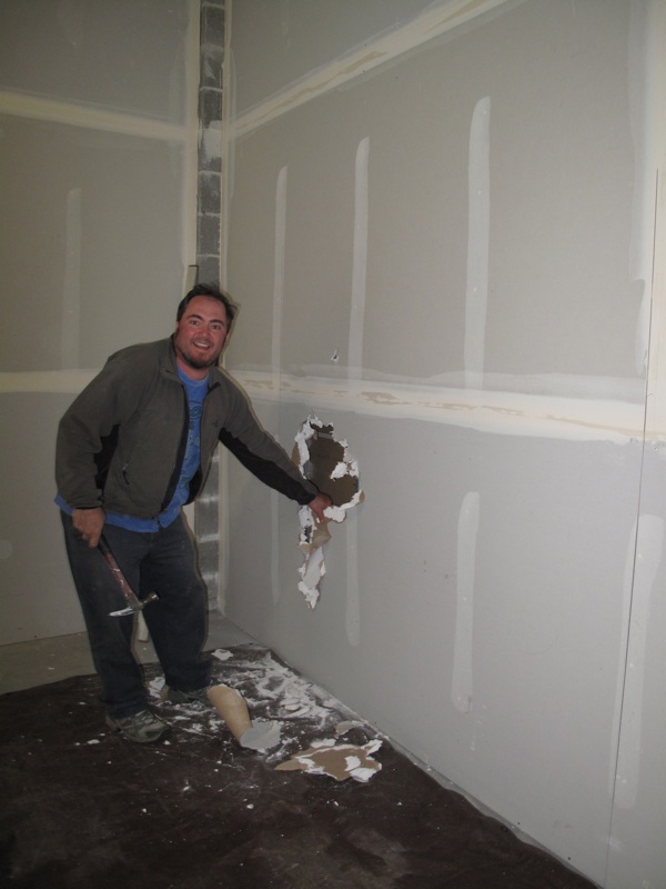Go Alan Go! Our contractor breaks into the wall that will join the main store space with the food room